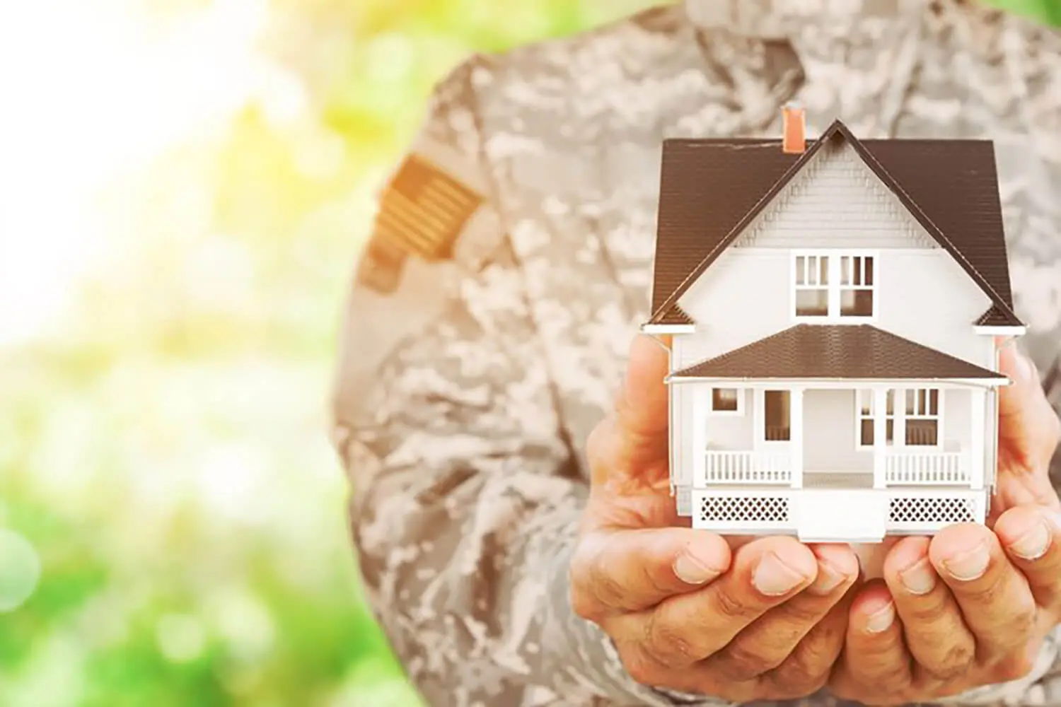 Military family holding a model house representing how military buyers evaluate risk when buying a home