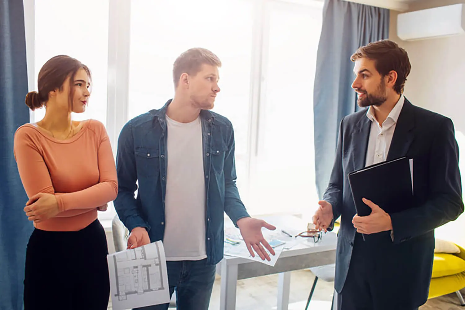 Homeowners discussing what sellers misjudge about pricing a home with a real estate agent during a property consultation