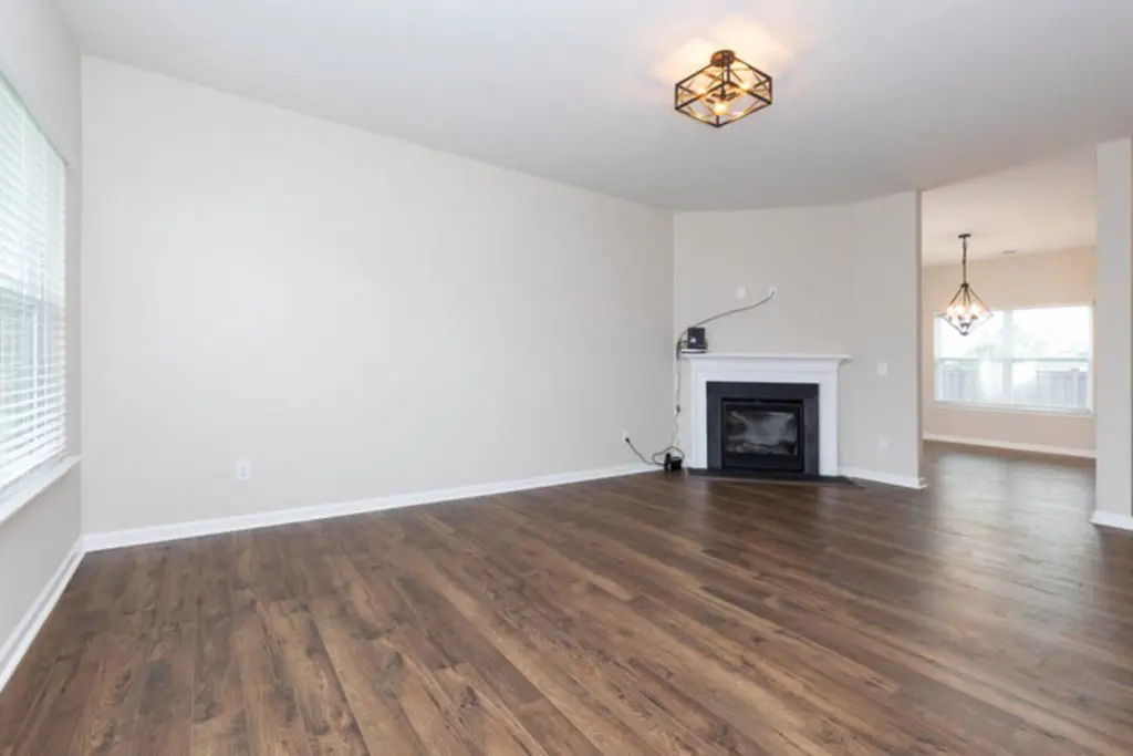 Empty living room with fireplace and hardwood floors in a Northern Virginia style home being prepared for sale