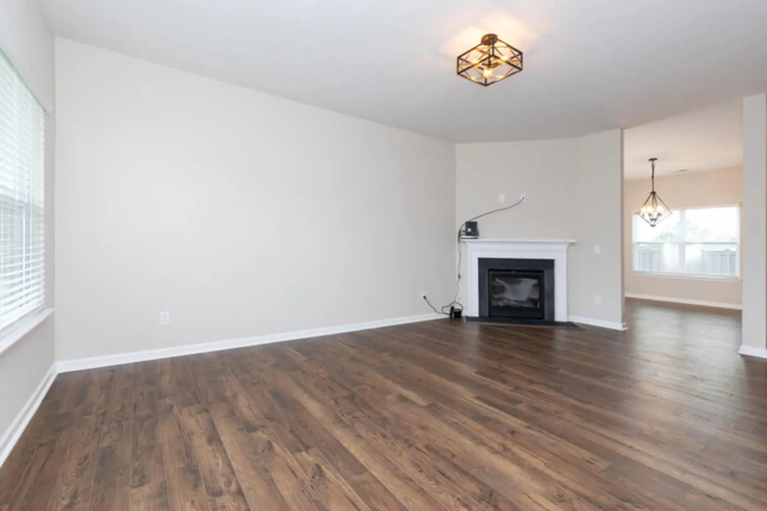 Empty living room with fireplace and hardwood floors in a Northern Virginia style home being prepared for sale